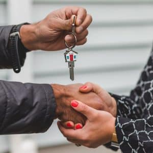 People shaking hands and exchanging keys